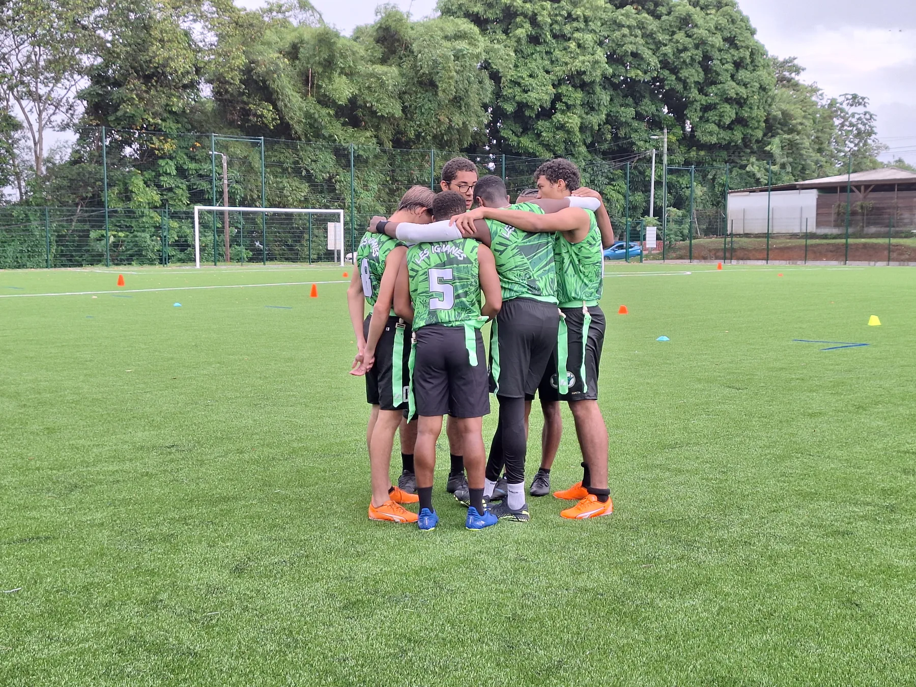 Joueurs des Iguanes réunis en cercle sur le terrain